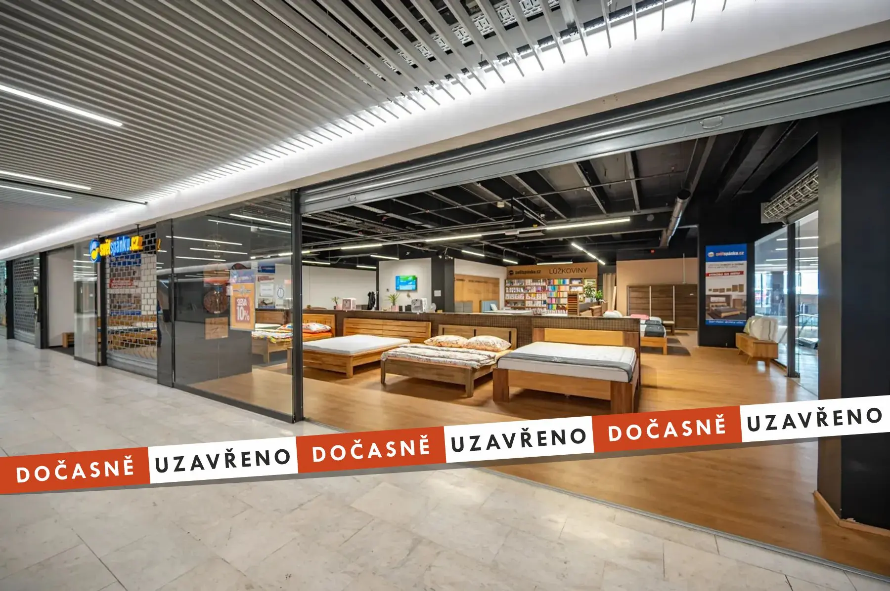 Prodejna ložnicového nábytku s několika vystavenými dřevěnými postelemi, matracemi a regály s lůžkovinami.